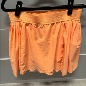 ALO YOGA- ACES TENNIS SKIRT - CANTELOUPE